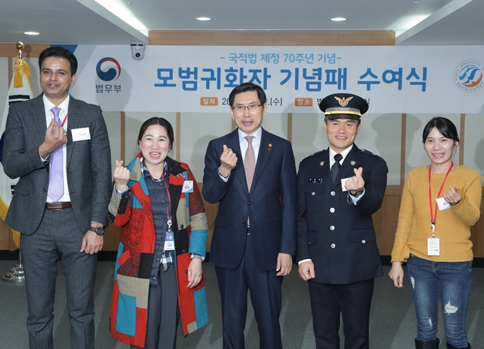 El 19 de diciembre el ministro de Justicia Park Sang-ki (centro) y los ‘naturalizados ejemplares’ posan en la ceremonia de entrega de placas de premio de los naturalizados ejemplares en el Complejo Gubernamental de Gwacheon.